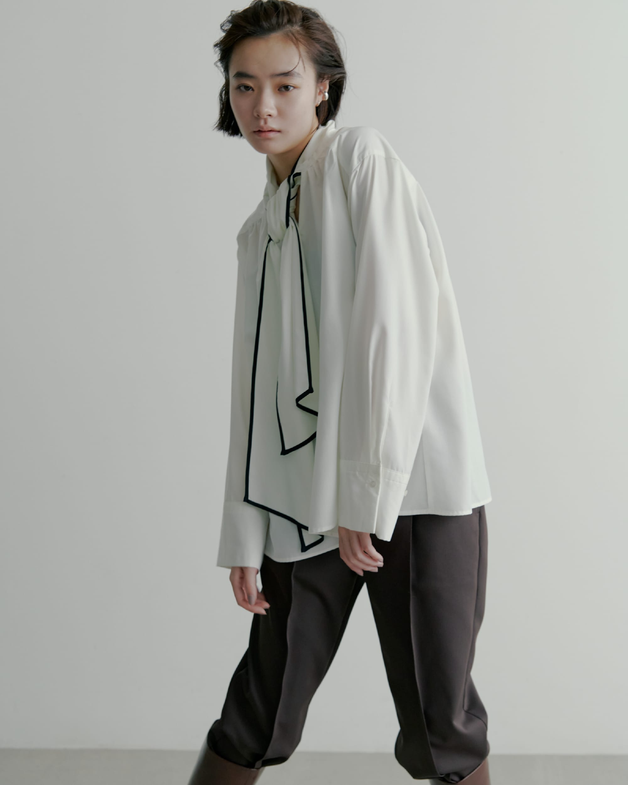 ノーカラーサイドリボンサテンBL&recycleサテンテーパードPT&ＬＯＮＧ　ＢＯＯＴＳ&EARCUFFSETを着た女性