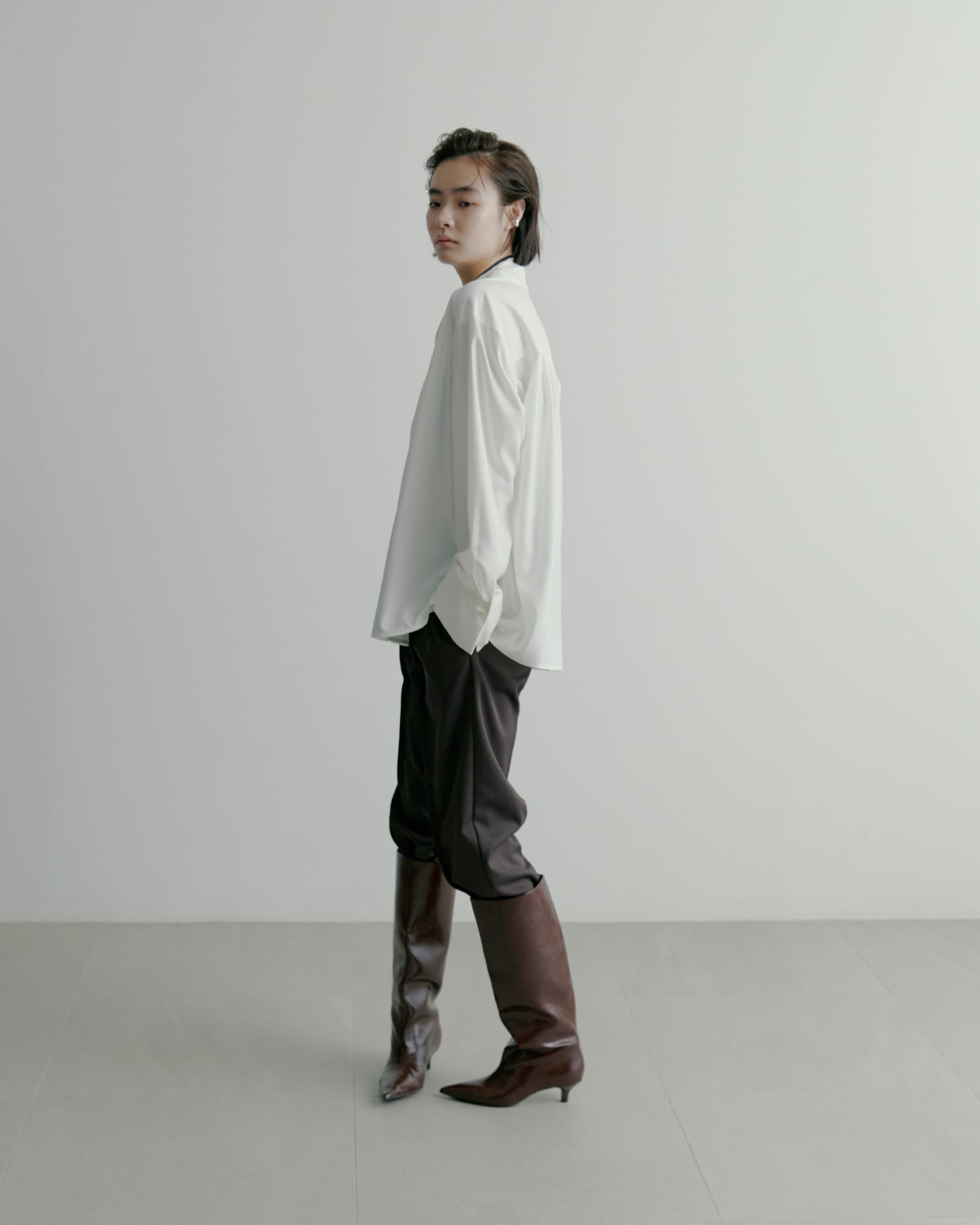 ノーカラーサイドリボンサテンBL&recycleサテンテーパードPT&ＬＯＮＧ　ＢＯＯＴＳ&EARCUFFSETを着た女性