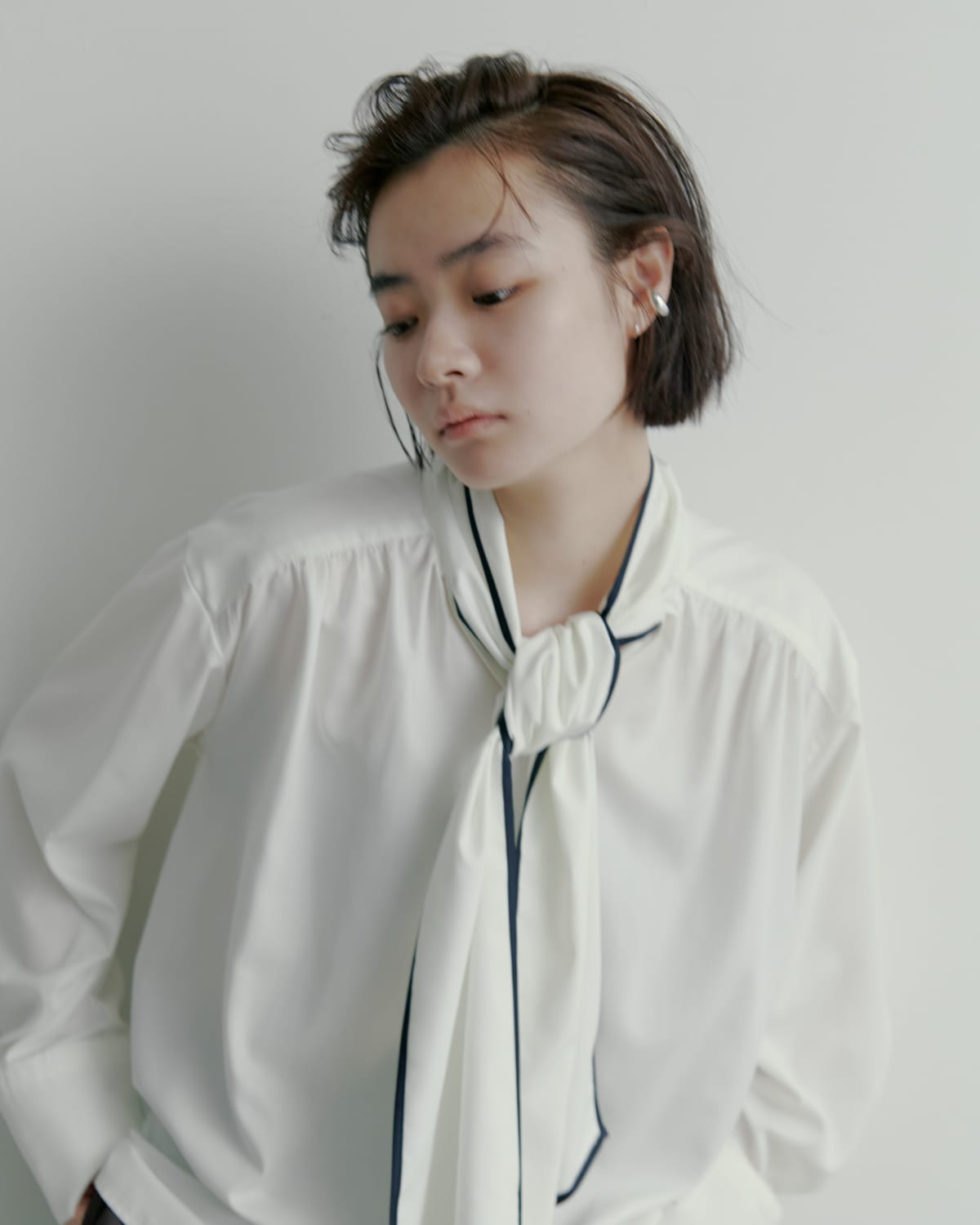 ノーカラーサイドリボンサテンBL&recycleサテンテーパードPT&ＬＯＮＧ　ＢＯＯＴＳ&EARCUFFSETを着た女性