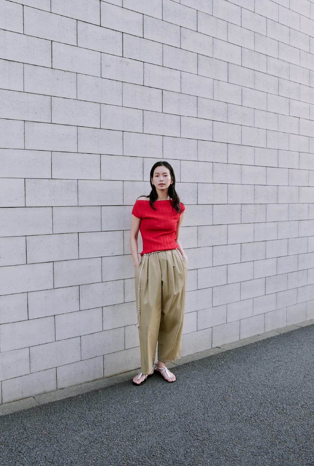シュリンクフレンチニットTOPS&リサイクルコクーンギャザーデザインPT&BEADS BELTを着た女性