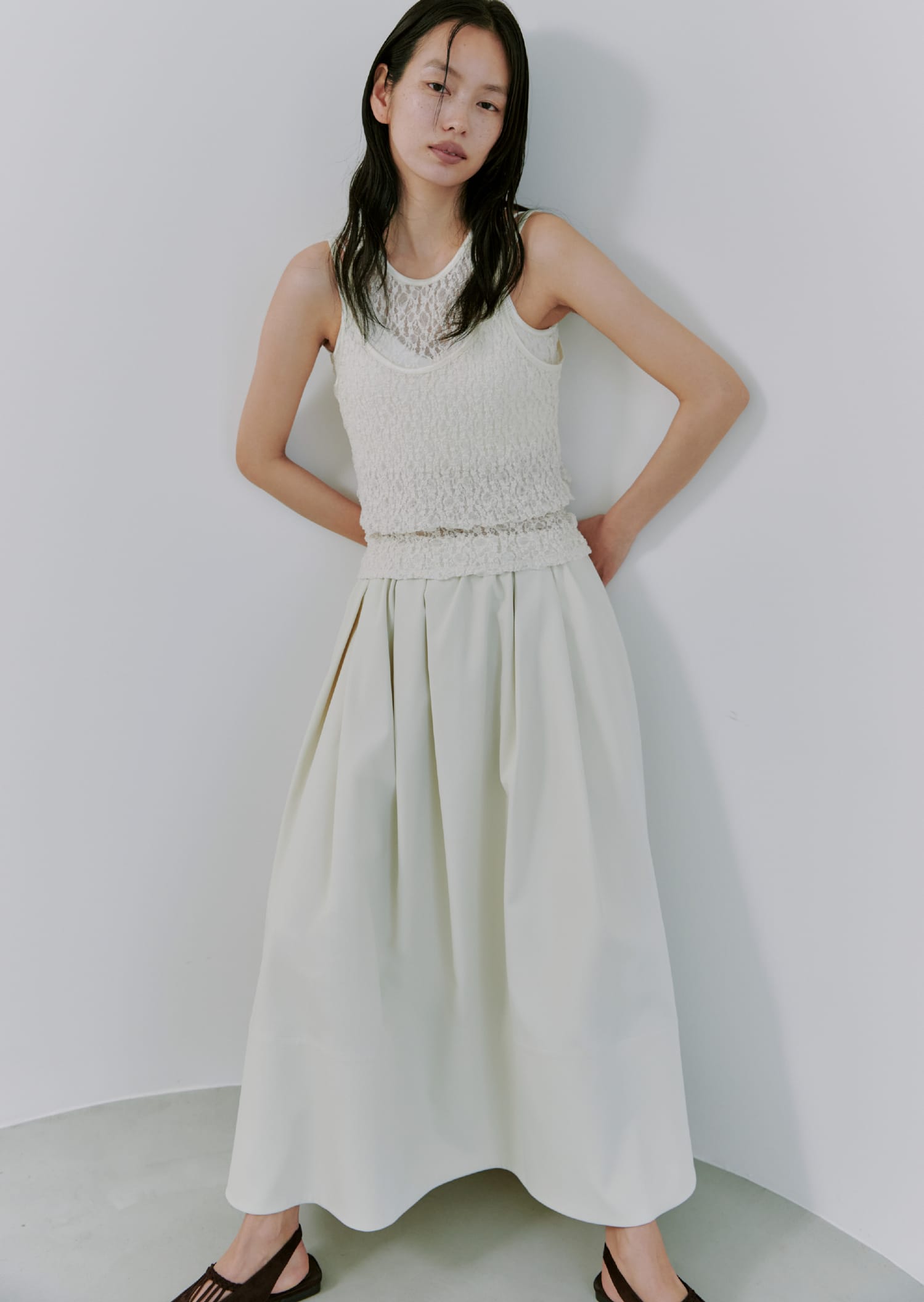レースレイヤードカットTOPS&ナイロンツイルボリュームSK&SUEDE SLINGBACK PUMPSを着た女性