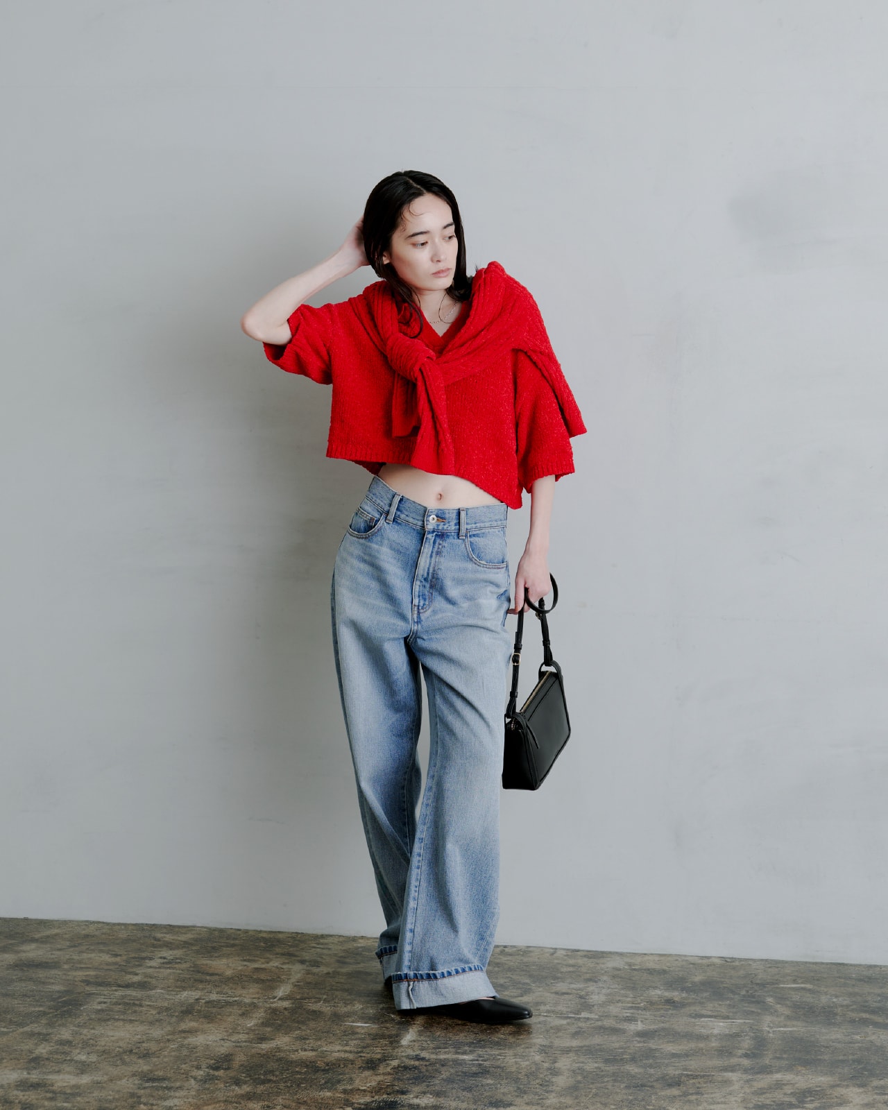 赤いトップスを着た女性が正面を向いている画像