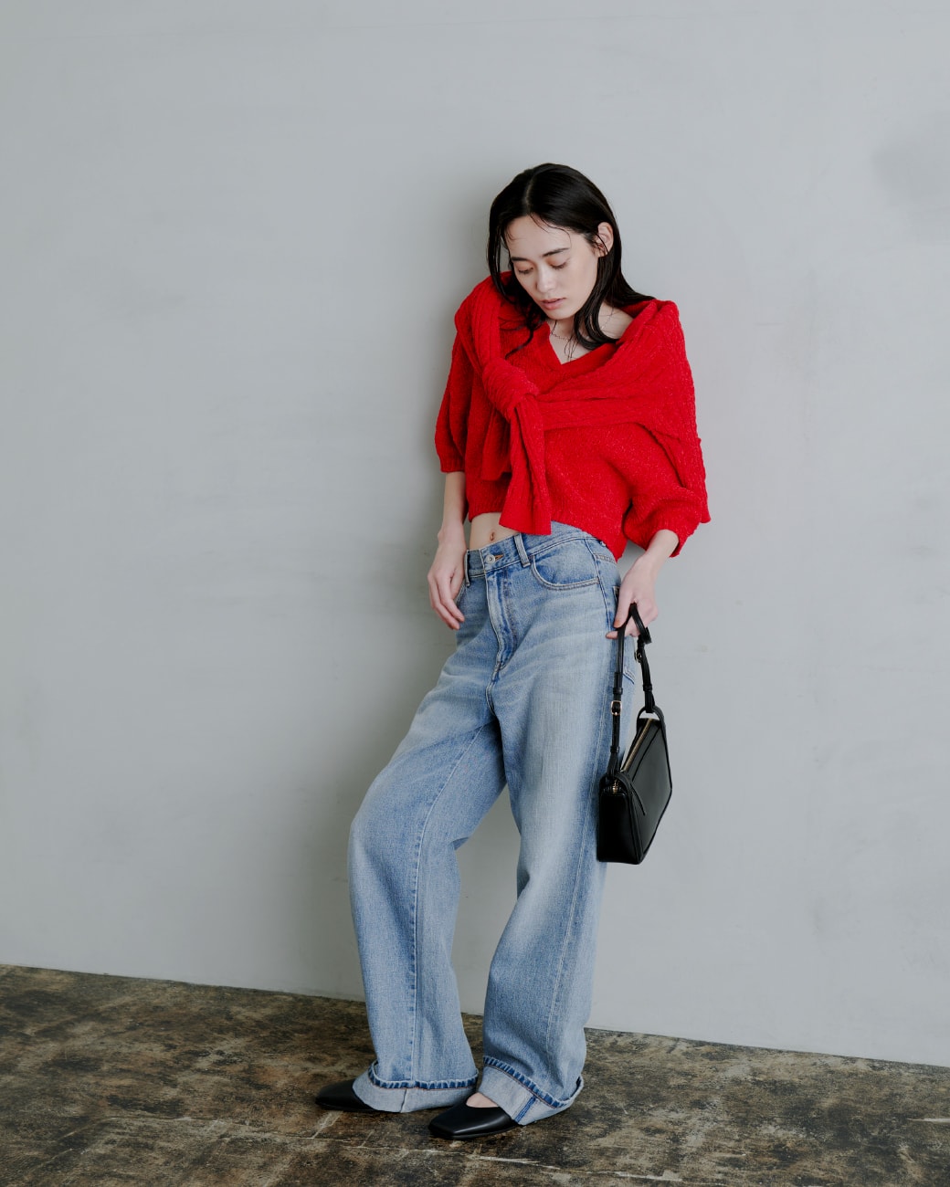 赤いトップスを着た女性が正面を向いている画像