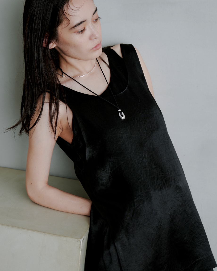 黒いワンピースを着た女性が右を向いている画像