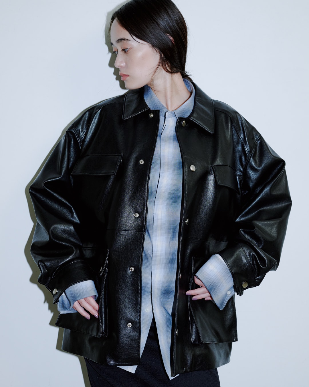黒いジャケットに黒いパンツを着た女性が正面を向いている画像