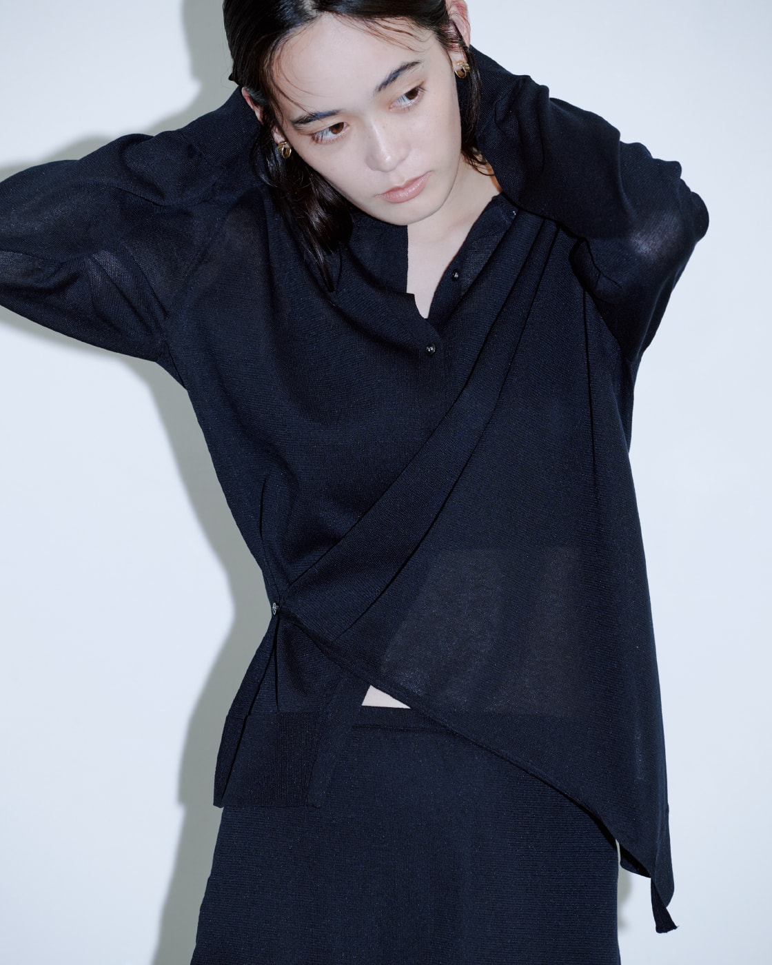 黒いトップスに黒いパンツを着た女性が正面を向いている画像