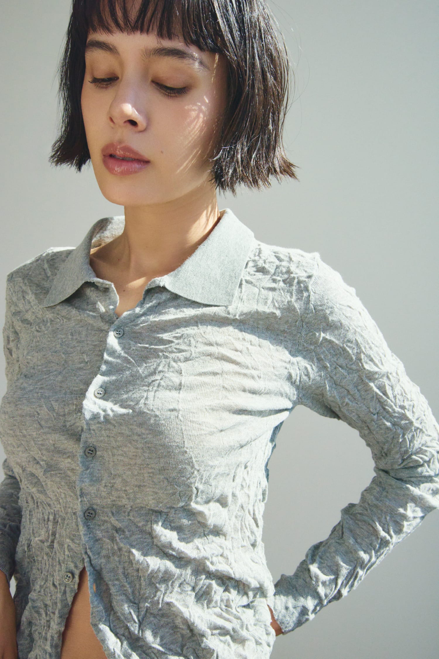 ワッシャーニットシャツ&からみ織りセミフレアスカート&レザートングストラップサンダル&レザーベルトを着用した女性