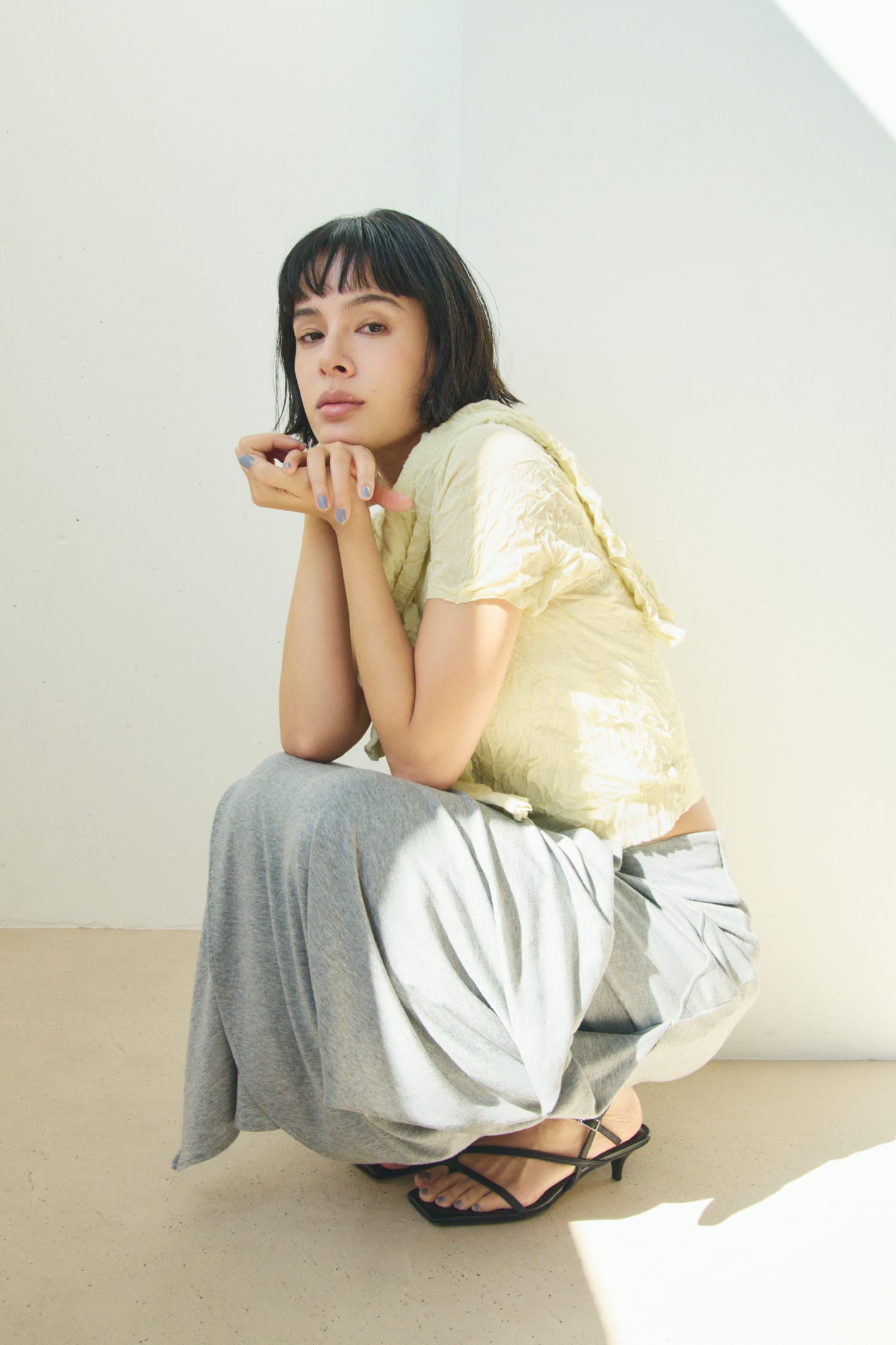 ワッシャーニットＴ&ワッシャーニットシャツ&ニュアンスドレープカットスカート&レザートングストラップサンダルを着用した女性