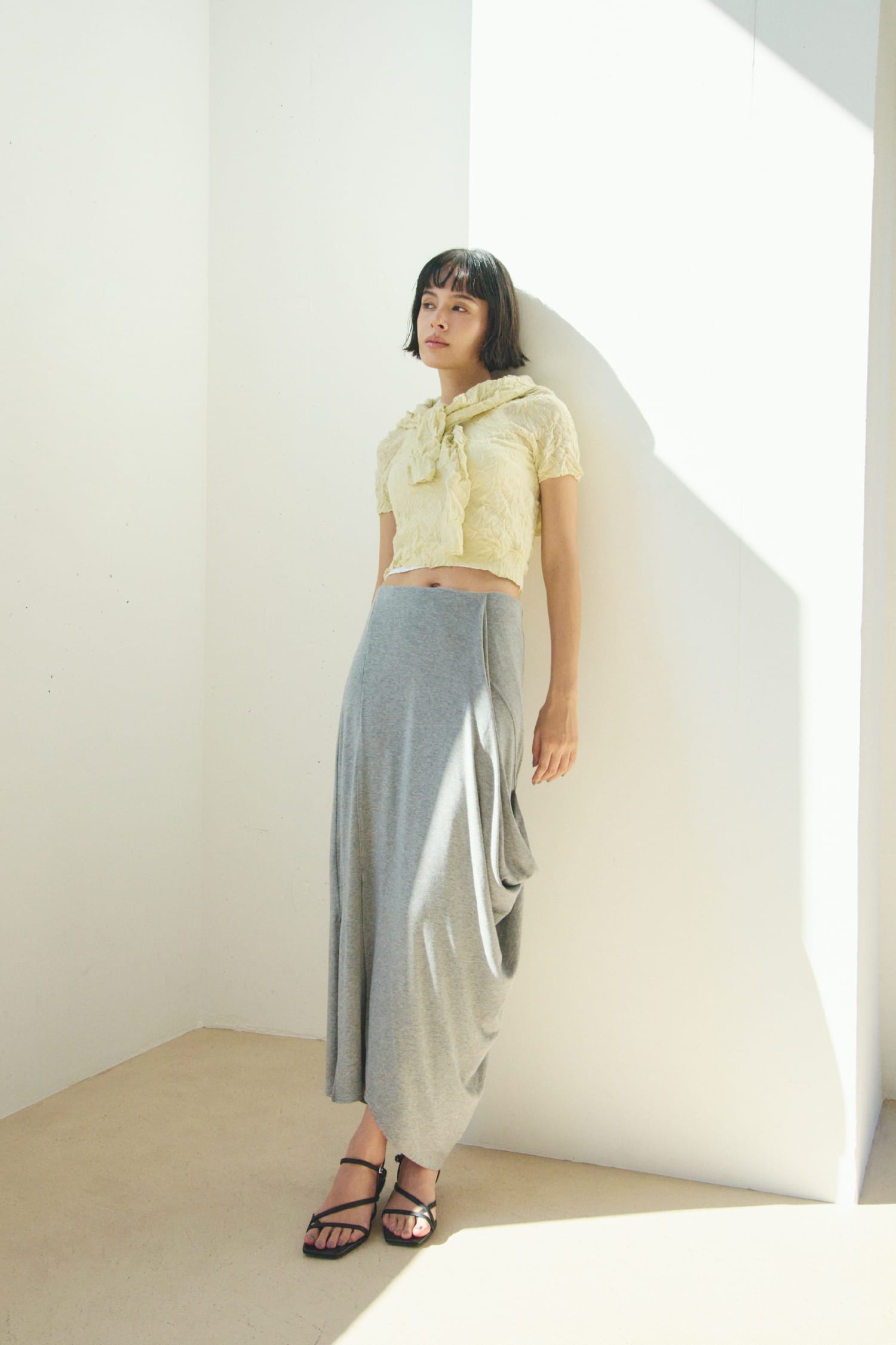 ワッシャーニットＴ&ワッシャーニットシャツ&ニュアンスドレープカットスカート&レザートングストラップサンダルを着用した女性