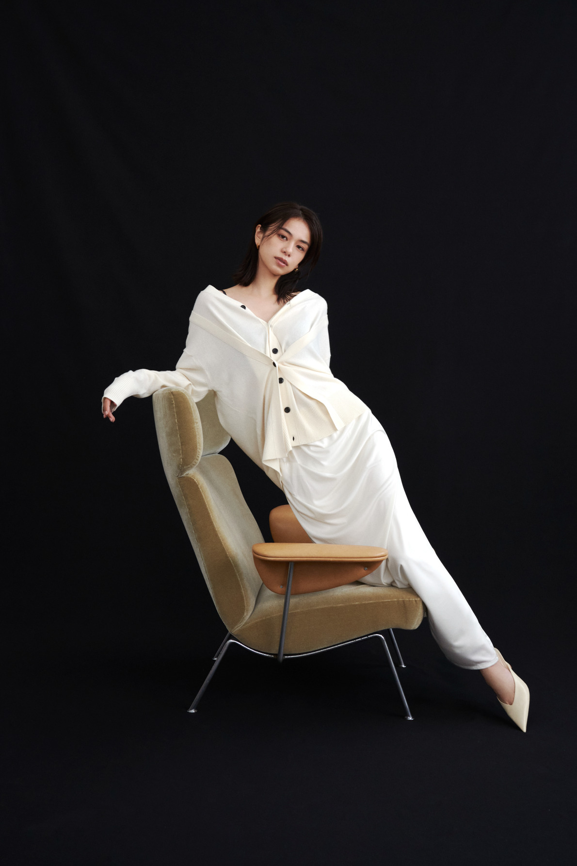 白のブラウスとスカートを着て椅子に腰掛ける佐藤晴美（look 01 2枚目）