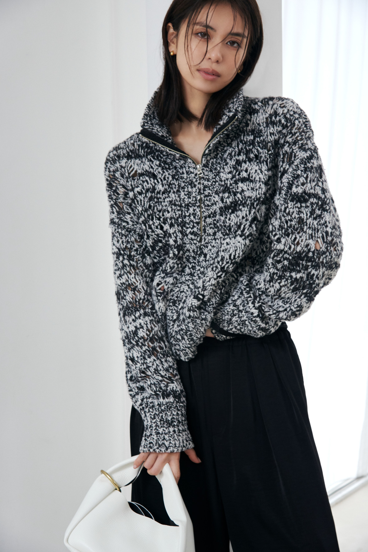Look10 グレーのニットとバッグを持った着用カット